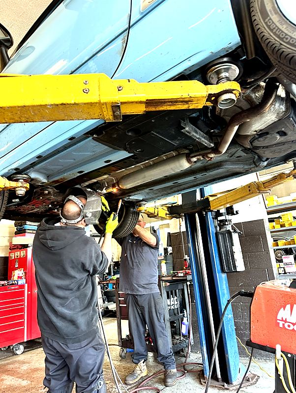 West Goshen Automotive & Fleet Services technicians repairing the exhaust system on a vehicle in the West Chester, PA shop